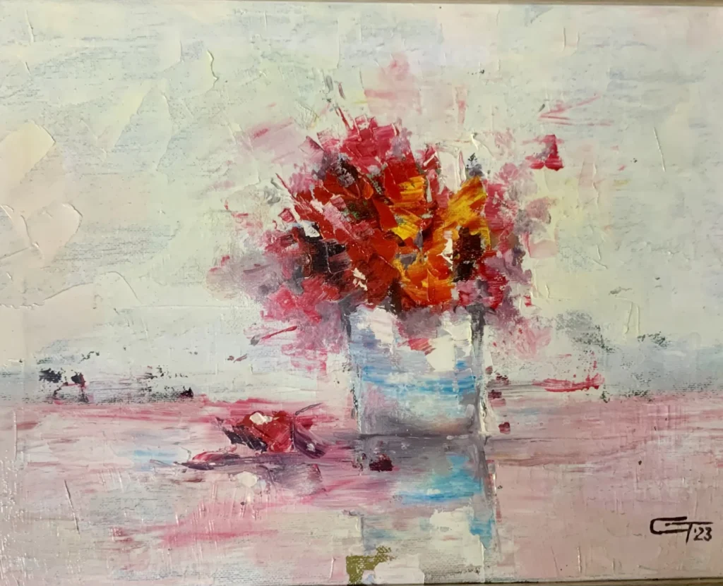 Buchet de flori roșii într-un vas, pe fond pal